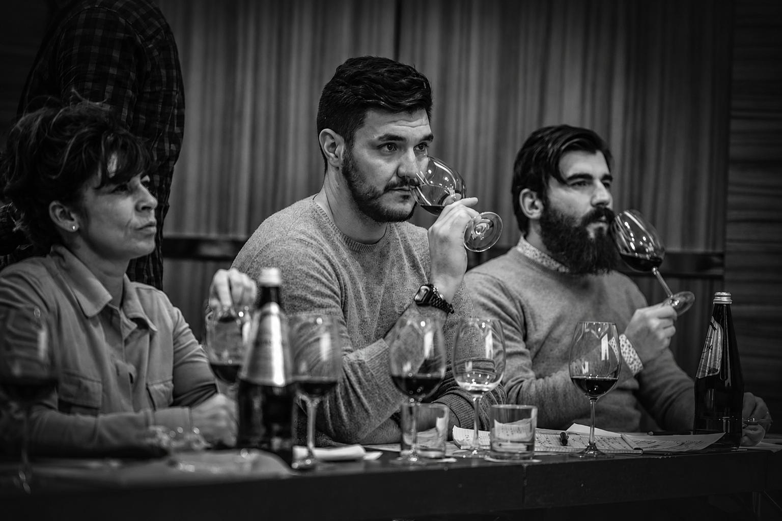 Corsista assapora un calice di vino rosso durante la degustazione