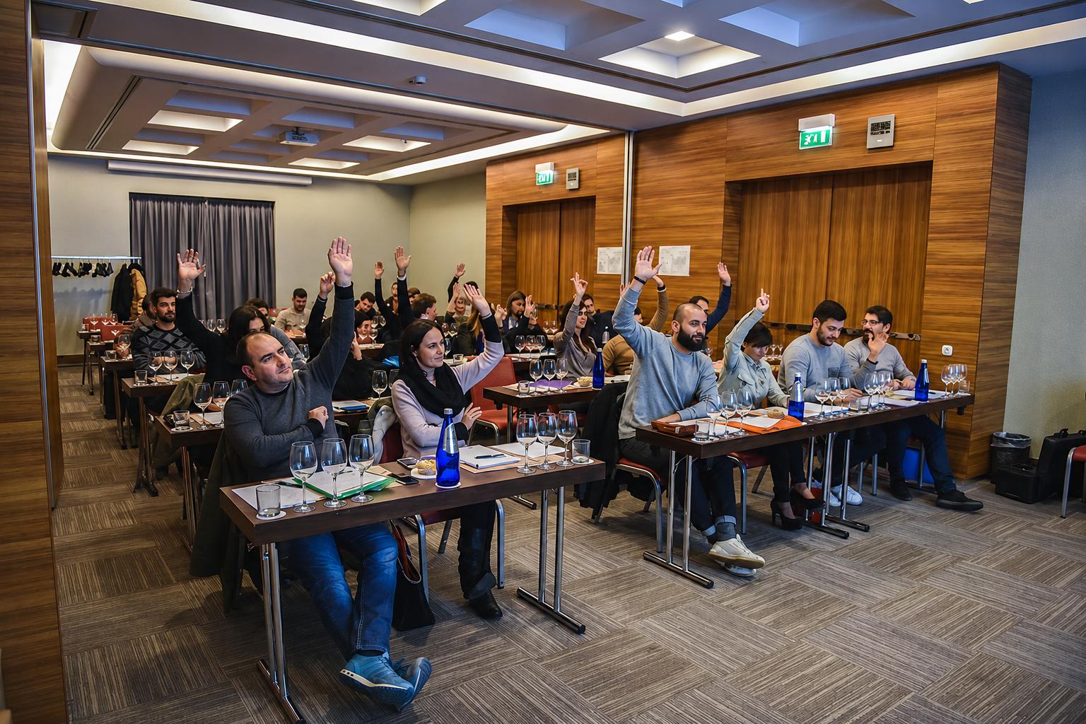 Aula del corso con i partecipanti che alzano la mano